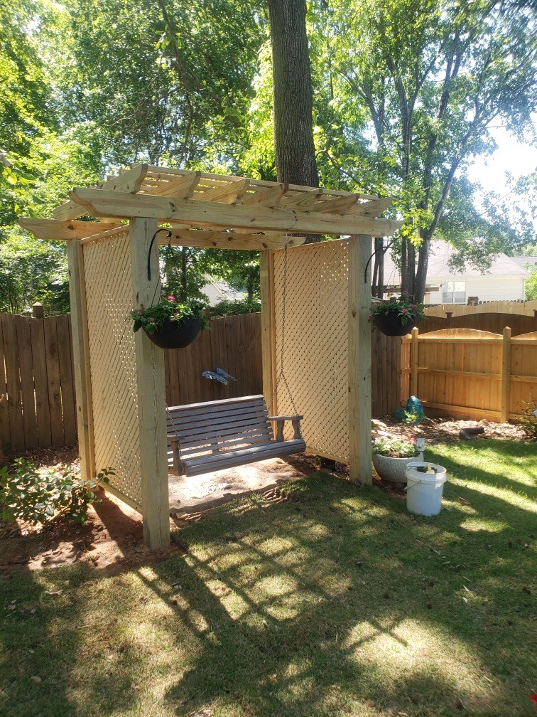 Beautiful gazebo and swing in a yard of a residential neighborhood.